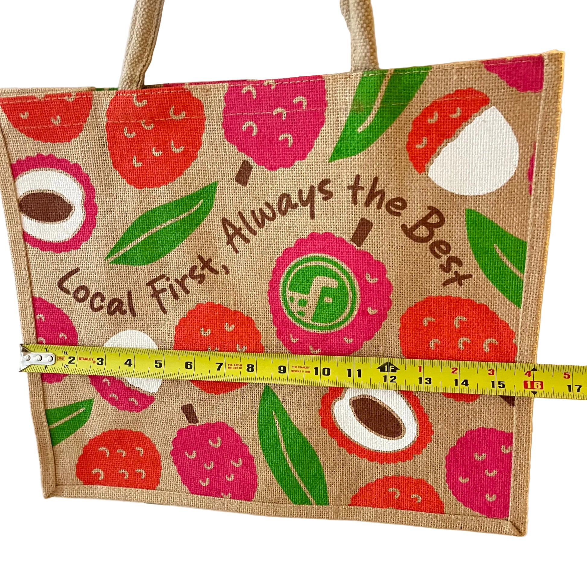 Jute bag with fruit pattern and text, measured by a tape measure.
