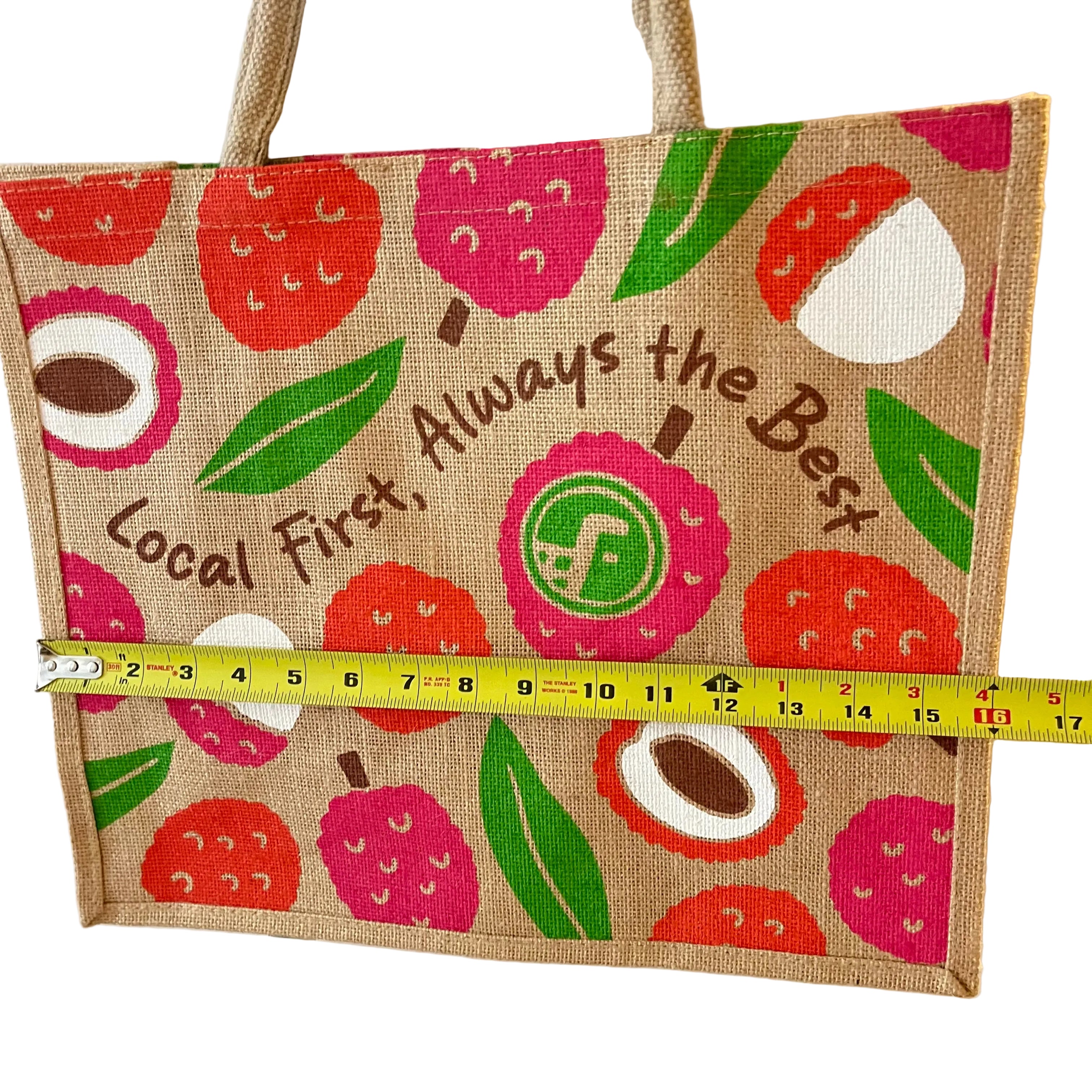 Jute bag with fruit pattern and text, measured by a tape measure.