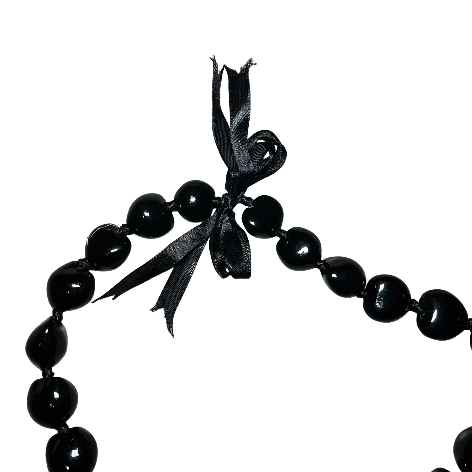 Black beaded necklace with a ribbon on a white surface
