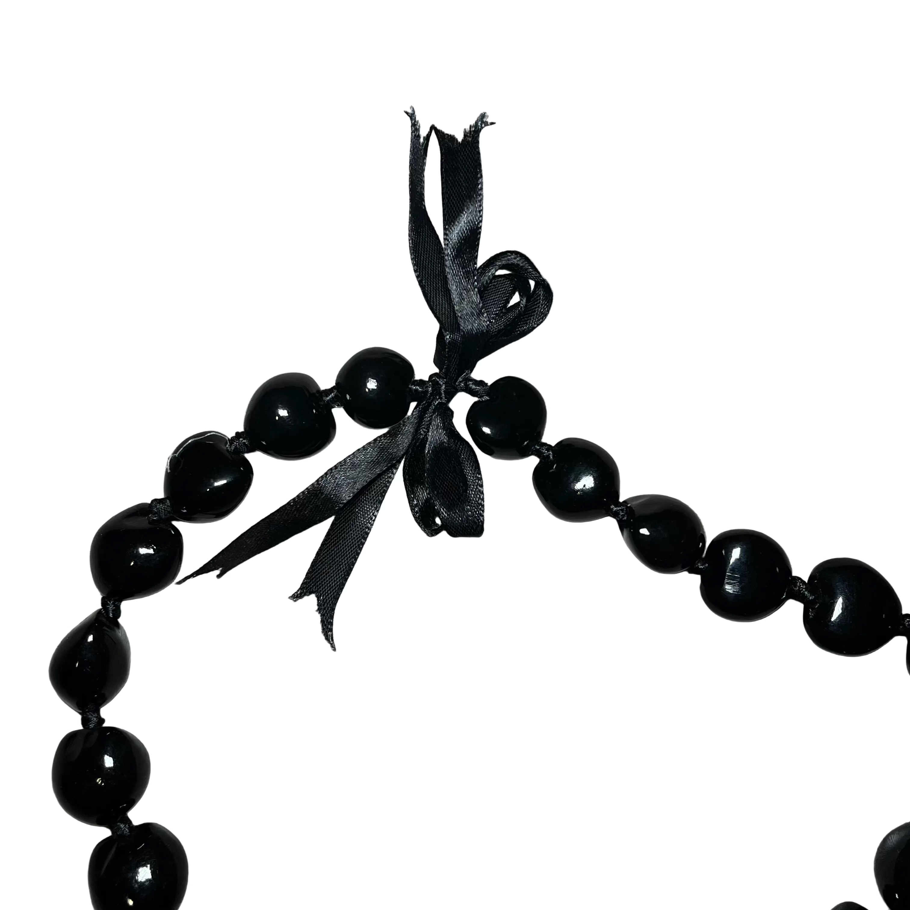 Black beaded necklace with a ribbon on a white surface