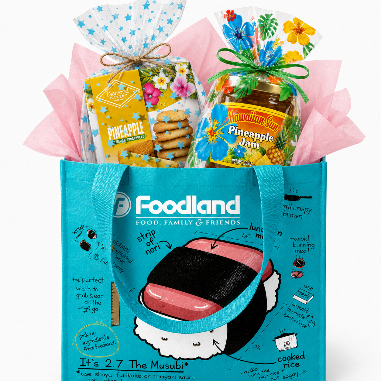 A gift basket featuring a large blue tote bag with sushi-themed graphics, filled with packaged snacks and a jar of pineapple jam, arranged with pink tissue paper on a white background.